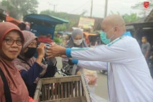 BAKTI SOSIAL MEMBAGIKAN APD BERUPA FACE SHIELD KEPADA SEJUMLAH PEDAGANG PASAR DAN MASYARAKAT